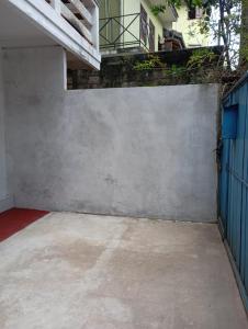 a concrete wall with a blue gate and a balcony at Summer Villa in Badulla
