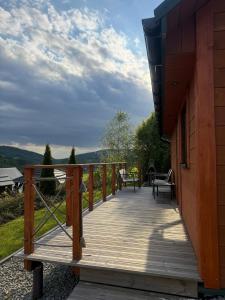 una terrazza in legno con tavolo e sedie su una casa di Zielony Raj - Bieszczady a Wańkowa