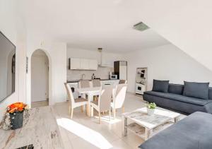 Una sala de estar con un sofá azul y una mesa. en Vienna Airport Residences, en Himberg