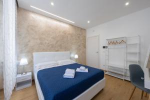 a bedroom with a blue bed with two towels on it at San Pietro Roma Suite in Rome