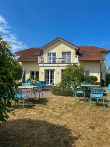 a group of chairs and tables in front of a house at Villa am Weinberg mit Garten großzügig und exklusiv in Geisenheim
