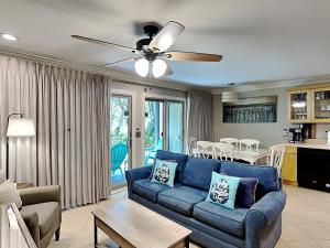a living room with a blue couch and a table at Inlet Dunes #102 in Inlet Beach