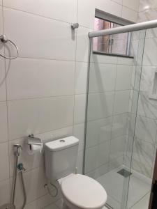 a white bathroom with a toilet and a shower at Hostel Miscelânea in Sete Lagoas +13 photos