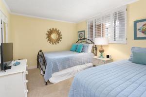 Un dormitorio con dos camas y un televisor. en North Breakers #300, en Saint Simons Island
