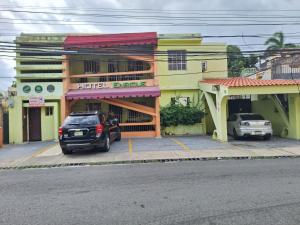 a car parked in a parking lot in front of a building at Hotel Enrique I Gazcue, Bed and Breakfast in Santo Domingo