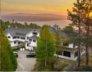 a house with a car parked in a driveway at Domaine Fairbanks in La Malbaie