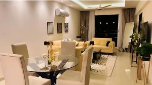 a dining room and living room with a glass table and chairs at Elysium Tower Premium Hotel Serviced Apartments Islamabad in Islamabad +48 photos