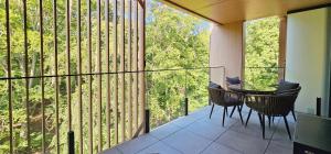 eine überdachte Veranda mit Tisch und Stühlen auf einem Balkon in der Unterkunft HolidayHomePL Sea & Forest D344 z sypialnią, basen, spa, gym GRATIS in Misdroy