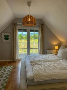 a bedroom with a large bed and a large window at Villa am Weinberg mit Garten großzügig und exklusiv in Geisenheim