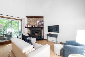 a living room with a couch and a fireplace at Les Manoirs 3bdrs Near Village in Mont-Tremblant