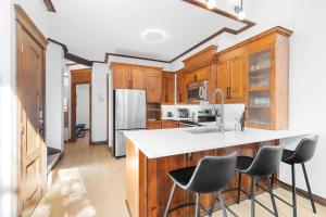 a kitchen with wooden cabinets and a white counter top at Les Manoirs 3bdrs Near Village in Mont-Tremblant +34 photos