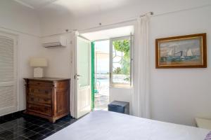 a bedroom with a bed and a dresser and a window at Il Carrubo Capri in Anacapri