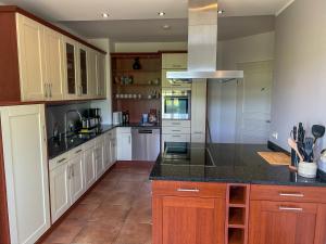 a kitchen with white cabinets and black counter tops at Villa am Weinberg mit Garten großzügig und exklusiv in Geisenheim