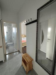 a mirror on a wall with a wooden stool in a room at Apartmani Vidušin in Novalja +37 photos