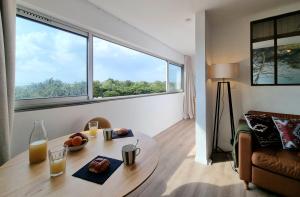 a living room with a table and a large window at L'Horizon doré, Vue mer et dunes, Plage à pied in Saint-Hilaire-de-Riez