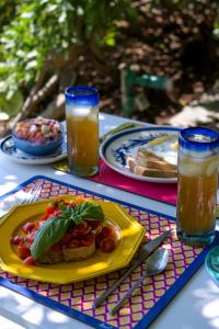 a table with a yellow plate of food and drinks at Il Carrubo Capri in Anacapri