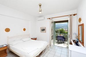 een slaapkamer met een bed en een balkon bij Pansion Prodromina in Skopelos Town