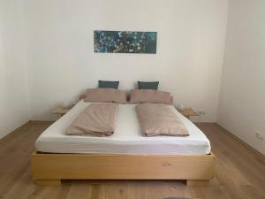 Bett in einem Zimmer mit einem Bettrahmen aus Holz in der Unterkunft Dein Rückzugsort in der Pfalz in Ruppertsberg