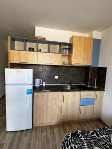 a kitchen with a white refrigerator and a sink at Aurora 1 Bedroom beach Apartment in Nesebar +3 photos