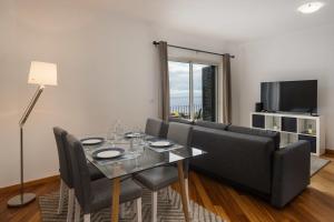 a living room with a table and a couch at Alta Vista Caniço by An Island Apart in Santa Cruz