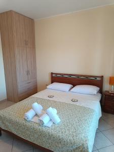 a bedroom with a bed with three rolled up towels at GEOMELOS Georgios APARTMENTS CHIOS in Chios