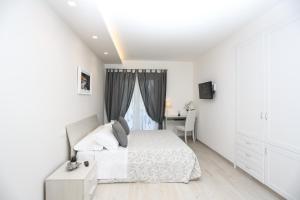 a white bedroom with a bed and a desk at Relais Villa Anna in Anacapri