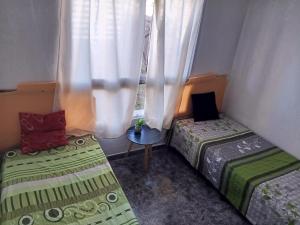 タフィ・デル・バジェにあるCasa hauseの窓のある小さな部屋にベッドが2つある