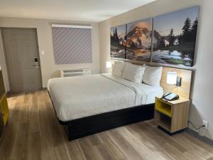 a hotel room with a large bed and a table at Days Inn by Wyndham Reno in Reno