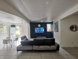 a living room with a couch and a table at Villa CYNNE Paradis Tropical in Baie-Mahault