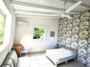 a living room with a couch and a window at Villa CYNNE Paradis Tropical in Baie-Mahault +22 photos
