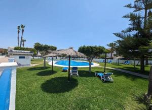 a resort with a pool and chairs and a umbrella at vera home shine in Vera