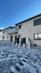 a large white building with a stone courtyard at Boardinghouse Living in Gemmingen