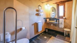 a bathroom with a toilet and a sink and a mirror at Casas Rurales Camino del Castaño in Galaroza +49 photos