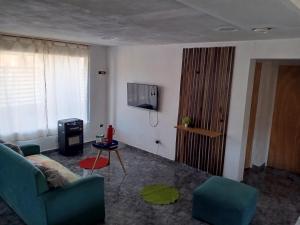 タフィ・デル・バジェにあるCasa hauseのソファとテレビのあるリビングルーム