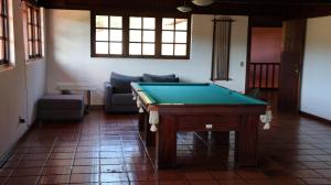 een pooltafel in een woonkamer met een bank bij Haras Santa Amalia - Nova União MG in União de Caeté