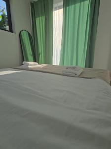 a bed with two towels sitting on top of it at Tiny Village Mamaia Nord - House 1 in Mamaia Nord