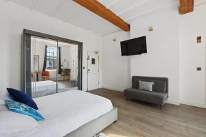 a bedroom with a bed and a chair and a television at Angel Townhouse in London