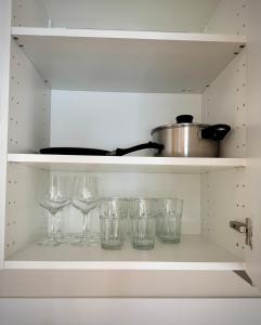 a shelf with wine glasses and a pot on it at Chic and Modern Studio - Central in Oslo +10 photos