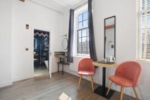 a room with two chairs and a table and a mirror at Angel Townhouse in London
