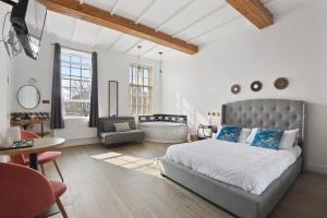 a bedroom with a bed and a bathroom with a tub at Angel Townhouse in London