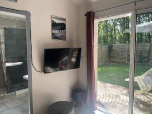 a tv on a wall next to a sliding glass door at Lasko in Pornic