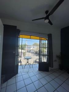 a living room with a ceiling fan and a table at Nueva Vista INN in Cruz de Huanacaxtle