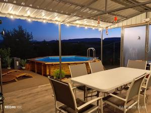 a patio with a table and a swimming pool at Mobile Home CARMINO in Turda