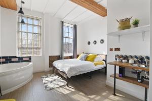 a bathroom with a bed and a tub and a sink at Angel Townhouse in London