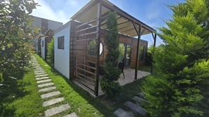 a small house in a garden with trees at Tiny Village Mamaia Nord - House 5 in Mamaia Nord