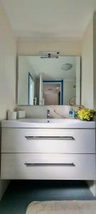 Un baño con un lavabo blanco y un espejo. en Villa Mimosa, en Bergeggi