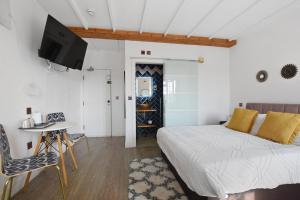a bedroom with a bed and a table and a tv at Angel Townhouse in London