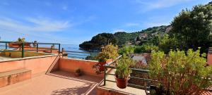 balcón con macetas y vistas al agua en Villa Mimosa, en Bergeggi