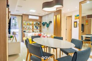 a living room with a table and chairs and a couch at Apto. com Jacuzzi em Cotovelo In Mare by QAVI in Granja Beira Mar