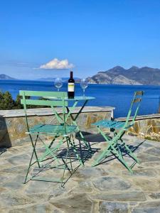a table with two chairs and a bottle of wine at NISIDA Resort & Meditation center - Adult only in Áno Fanárion